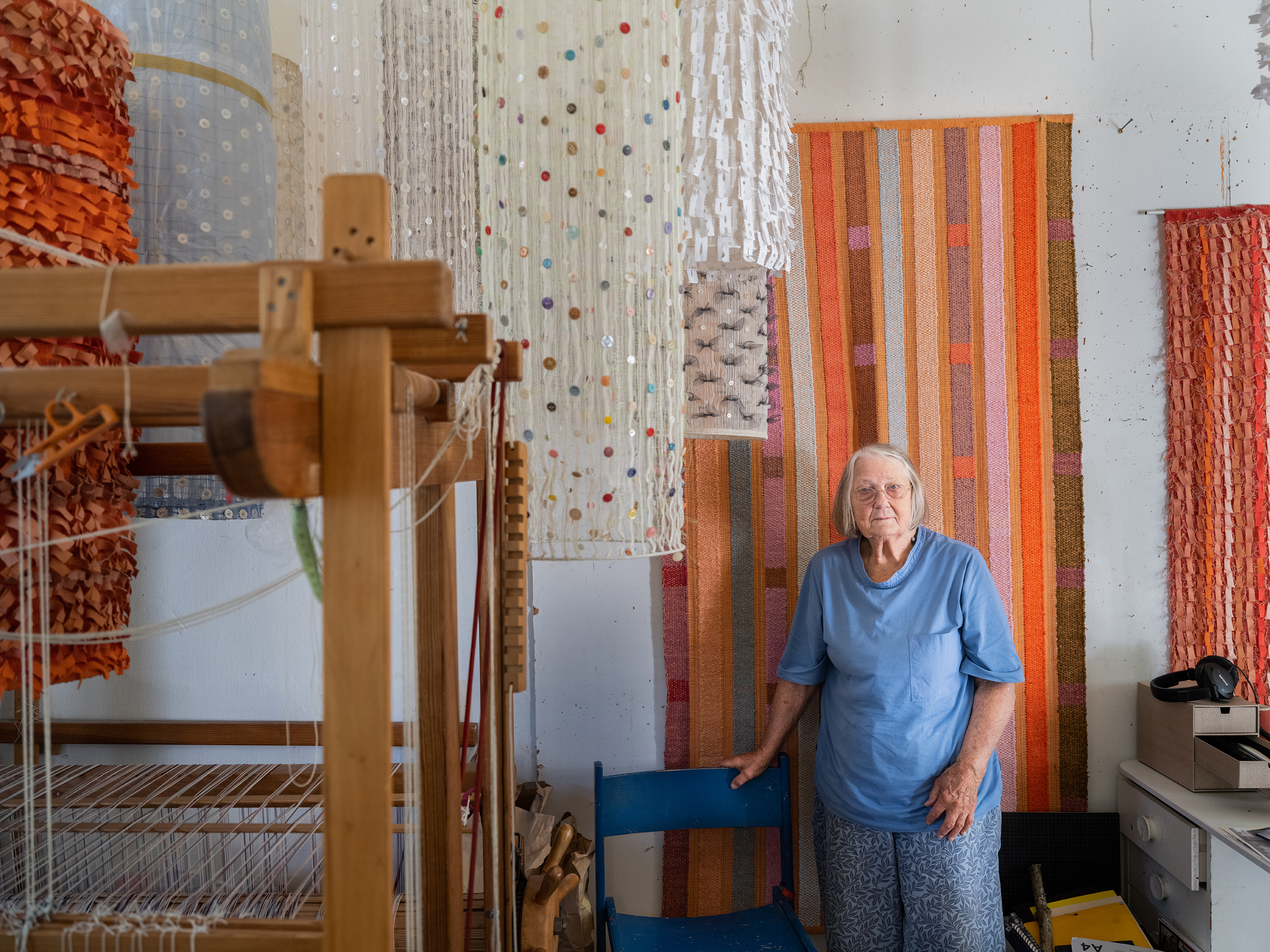 Foto: Nora Lorek. Kerstin Åsling-Sundberg, textilkonstnär som skapar textil för offentlig miljö, trasmattor med vävstol eller skirar knappvävar. Hon kom till konstepidemin 1986 innan den officiellt invigdes. – Då hade jag en pytteliten lokal, här där jag sitter nu var fortfarande BUP verksamhet. När de flyttade nåt år senare kom jag hit, rev två väggar och gjorde om två rum och en hall till det här som kom att bli min ateljé. Hon är pensionär, bor bara nerför gatan och kommer hit dagligen. 